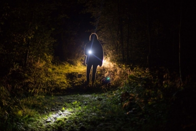 Person nachts mit Taschenlampe